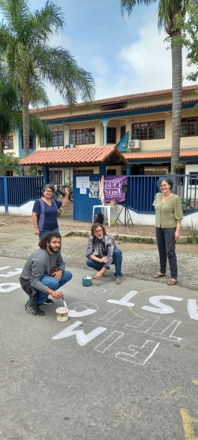 Acima, momento em que comunidade pinta a frases em defesa dos serviços públicos na entrada do campus em Rio das Ostras
